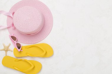 Beton arka planda renkli plaj aksesuarlarıyla yatıyordu. Tatil kavramı