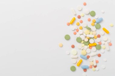Farklı ilaç ve kapsüller. Renkli arka plan, üst görünüm.