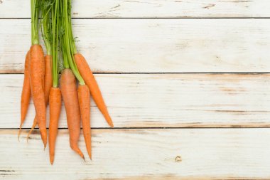 Ahşap zemin üzerinde taze havuç demeti, üst görünüm