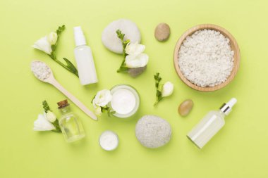 Renkli arka planda spa ürünleri ve çiçeklerle düz yatıyordu