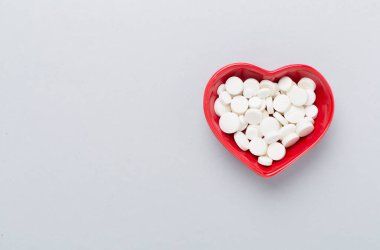 Kalp şeklindeki kase içindeki ilaçlar, arka plan, üst görünüm