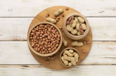 Ahşap arka planda soyulmuş ve soyulmamış fıstıklar.