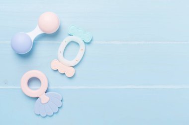 Ahşap arka planda renkli bebek çıngırakları ve oyuncakları, üst manzara