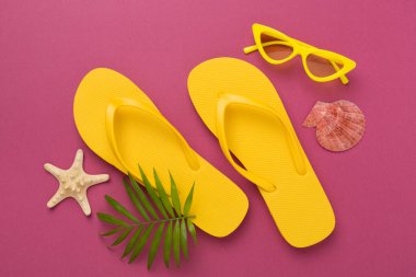 Renkli arka planda parlak sarı parmak arası terlikler, üst manzara. Yaz konsepti