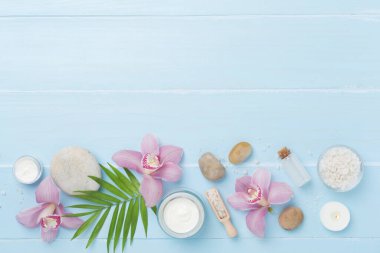 Orkideli kompozisyon, ahşap arka planda spa ürünleri, üst görünüm