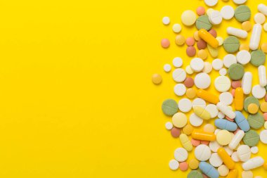 Farklı ilaç ve kapsüller. Renkli arka plan, üst görünüm.