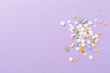 Farklı ilaç ve kapsüller. Renkli arka plan, üst görünüm.