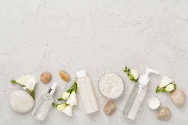 Beton zemin üzerinde spa ürünleri ve çiçeklerle yatıyordu