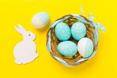 Ahşap arka planda tavşanlı mavi paskalya yumurtaları.