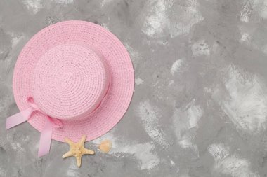 Beton arka planda pembe şapka, üst manzara. Yaz konsepti