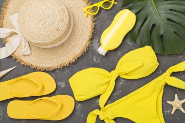 Beton arka planda renkli plaj aksesuarlarıyla yatıyordu. Tatil kavramı