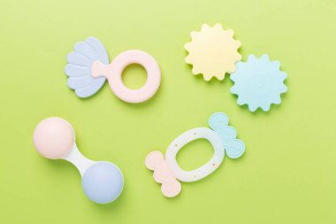 Renkli bebek tıngırtıları ve oyuncaklar arka planda, üst görünümde