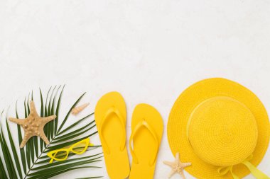 Beton arka planda sarı yazlık kıyafetlerle yatıyordu. Tatil kavramı