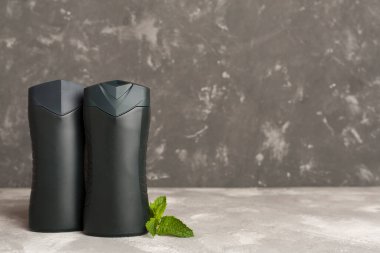 Erkekler, arka planda nane yapraklı kozmetik şişeleri.