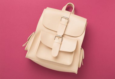 Renkli arka planda bej renkli sırt çantası, üst görünüm.