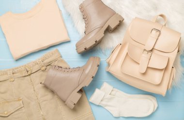 Ahşap arka planda modaya uygun bahar kıyafetleriyle yatıyordu.