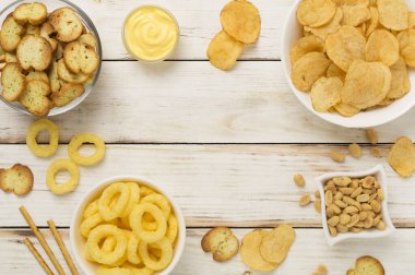 Ahşap arka planda çeşitli sağlıksız atıştırmalıklar.