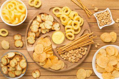 Ahşap arka planda çeşitli sağlıksız atıştırmalıklar.