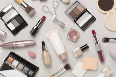 Beton zemin üzerinde makyaj ürünleri ve araçları ile düz yatıyordu