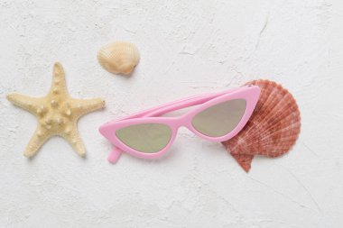 Beton arka planda zarif pembe güneş gözlükleri, üst manzara. Yaz konsepti