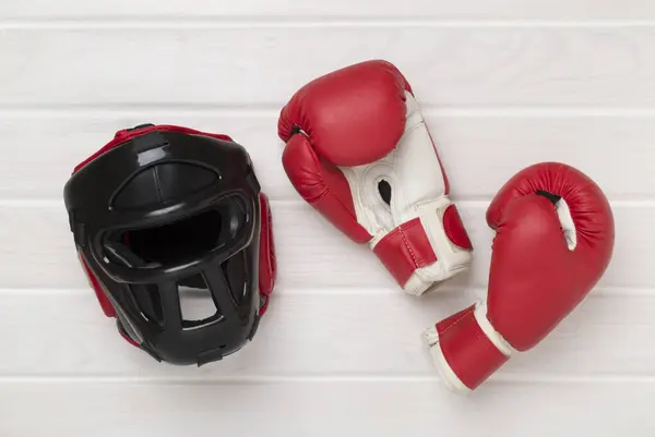 stock image Boxing helmet and gloves on wooden background, top view.