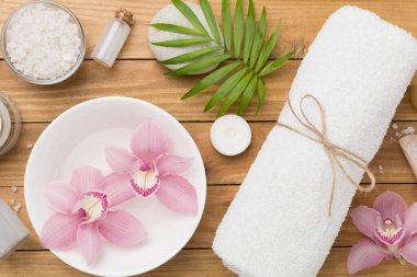 Orkideli kompozisyon ve ahşap zemin üzerinde masaj taşları, üst görünüm