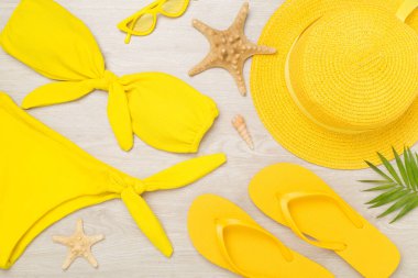 Tahta arka planda sarı yazlık kıyafetlerle yatıyordu. Tatil kavramı