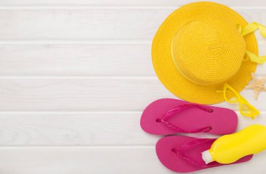 Ahşap arka planda renkli plaj aksesuarları olan düz bir yer. Tatil kavramı