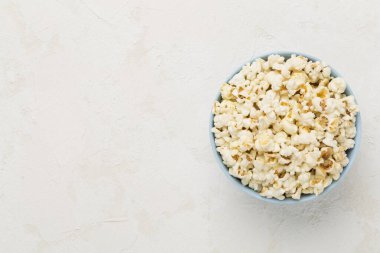 Beton arka planda, kasede lezzetli patlamış mısır.