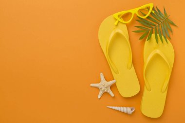 Renkli arka planda parlak sarı parmak arası terlikler, üst manzara. Yaz konsepti
