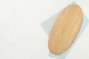 Beton arka planda peçeteyle kesme tahtası, üst görünüm