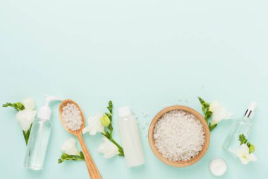 Renkli arka planda spa ürünleri ve çiçeklerle düz yatıyordu