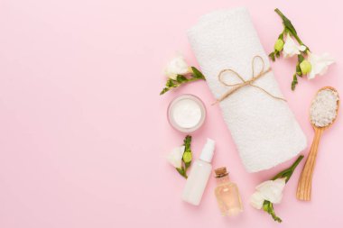 Renkli arka planda spa ürünleri ve çiçeklerle düz yatıyordu