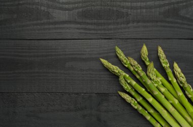 Fresh asparagus on wooden background, top view