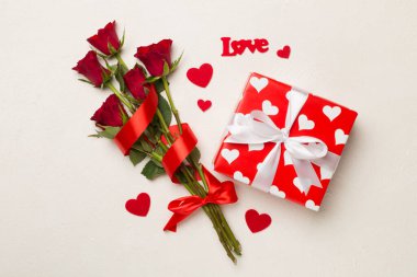 Beton arka planda hediye kutusu olan kırmızı gül çiçekleri, üst, manzara. Sevgililer Günü konsepti