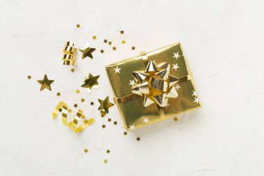 Altın hediye kutuları ve beton arka planda konfeti, üst manzara