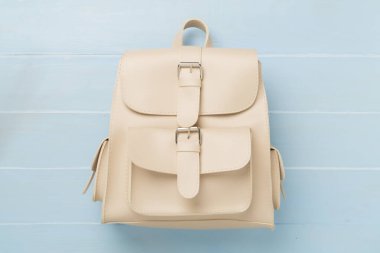 Renkli arka planda bej renkli sırt çantası, üst görünüm.