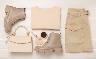 Ahşap arka planda modaya uygun bahar kıyafetleriyle yatıyordu.