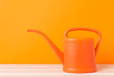 Tahta masadaki turuncu sulama kutusu.