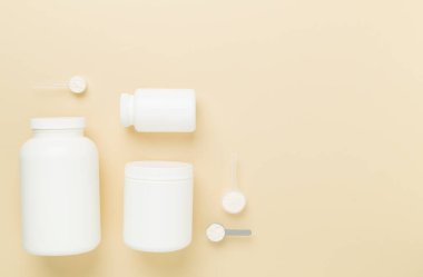 Renkli arka planda protein tozu olan kavanozlar, üst manzara. Spor beslenme konsepti