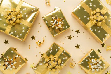 Altın hediye kutuları ve renkli arka planda konfeti, üst görünüm