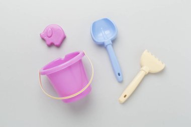 Renkli arka planda kumla oynamak için sevimli oyuncaklar, üst görünüm