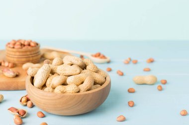 Ahşap masada soyulmuş ve soyulmamış fıstıklar.