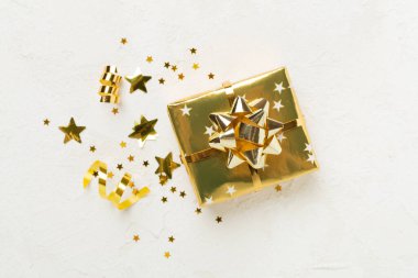 Altın hediye kutuları ve beton arka planda konfeti, üst manzara
