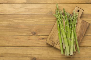 Fresh asparagus on wooden background, top view