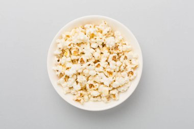 Renkli arka planda, kasede lezzetli patlamış mısır.