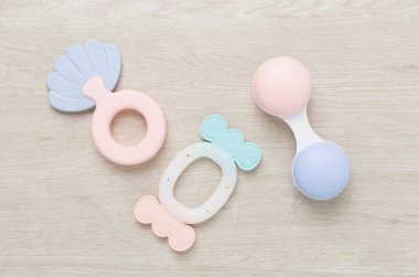 Ahşap arka planda renkli bebek çıngırakları ve oyuncakları, üst manzara