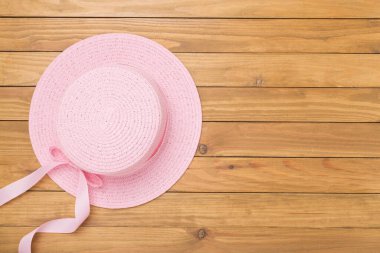 Ahşap arka planda pembe şapka, üst manzara. Yaz konsepti