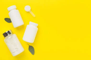 Renkli arka planda protein tozu olan kavanozlar, üst manzara. Spor beslenme konsepti