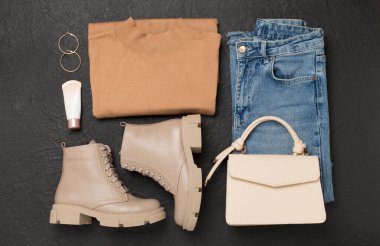 Beton arka planda modaya uygun bahar kıyafetleriyle yatıyordu.